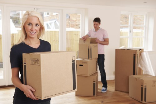 Man with van loading household items into a moving vehicle